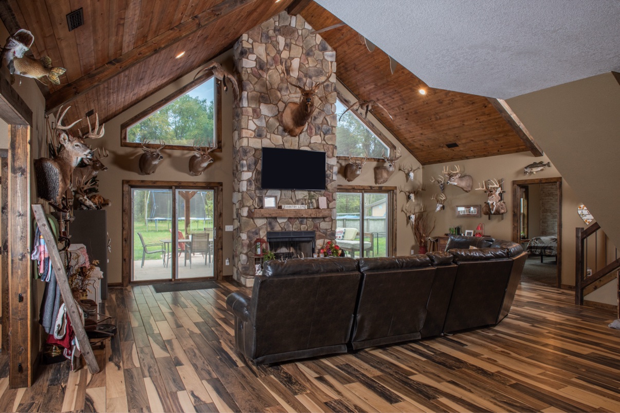 Cathedral ceiling great room with stone fireplace, wood ceilings and wide plank floors
